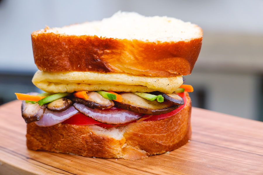 Fully loaded plant-based sandwich for vegans. Easy recipes with plant-based egg alternative JUST Egg. Photos by Rachel Gouk @ Nomfluence.